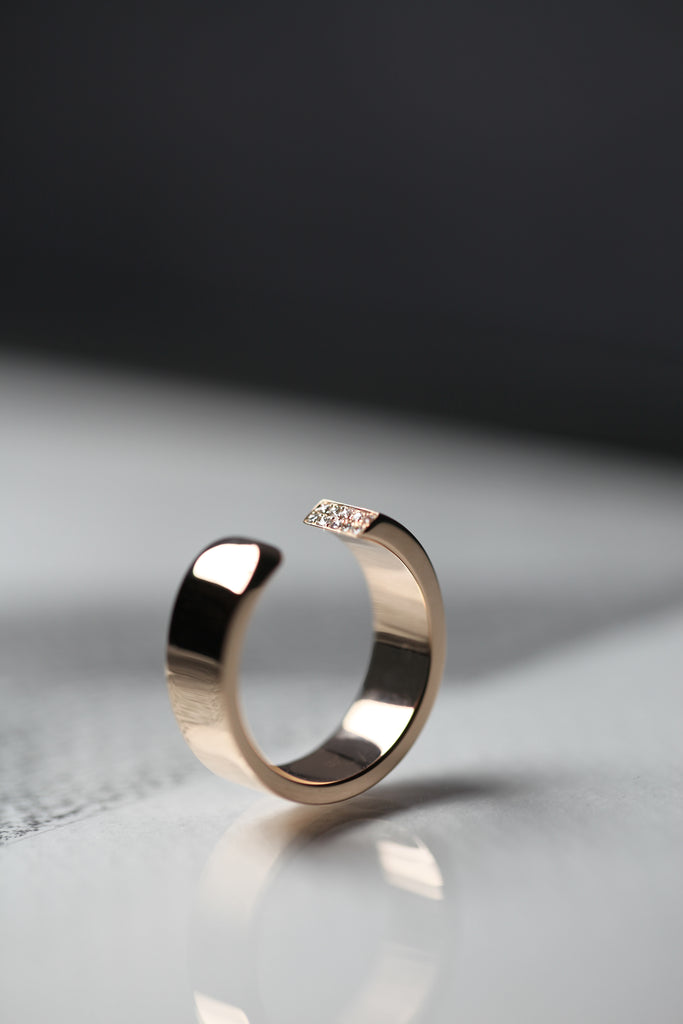 LA BEAUTÉ nous inspire le calme, une force intérieure et maîtrisée. Le parfait équilibre.   La sophistication dans la simplicité. Bague aux inspirations architecturales, ses formes pleines et denses se découpent de manière incisive. Deux rangs de diamants illuminent le biais et soulignent le contraste entre la droite et la courbe.