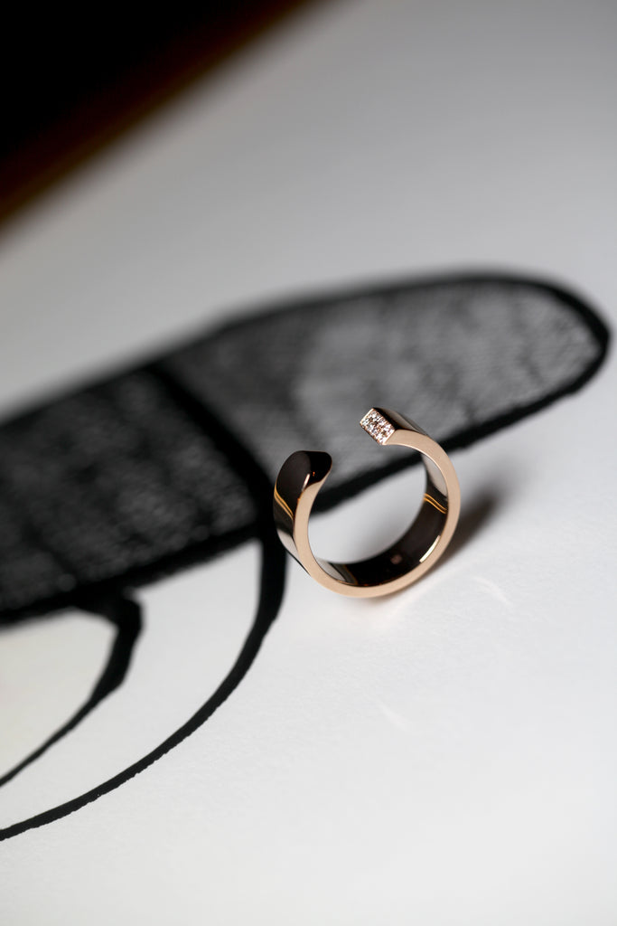 LA BEAUTÉ nous inspire le calme, une force intérieure et maîtrisée. Le parfait équilibre.   La sophistication dans la simplicité. Bague aux inspirations architecturales, ses formes pleines et denses se découpent de manière incisive. Deux rangs de diamants illuminent le biais et soulignent le contraste entre la droite et la courbe.