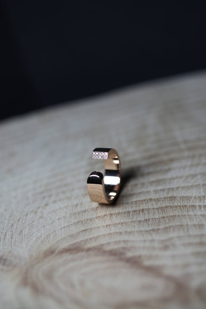 LA BEAUTÉ nous inspire le calme, une force intérieure et maîtrisée. Le parfait équilibre.   La sophistication dans la simplicité. Bague aux inspirations architecturales, ses formes pleines et denses se découpent de manière incisive. Deux rangs de diamants illuminent le biais et soulignent le contraste entre la droite et la courbe.