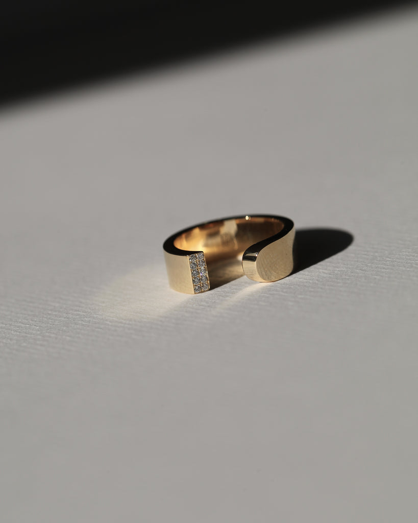 LA BEAUTÉ nous inspire le calme, une force intérieure et maîtrisée. Le parfait équilibre.   La sophistication dans la simplicité. Bague aux inspirations architecturales, ses formes pleines et denses se découpent de manière incisive. Deux rangs de diamants illuminent le biais et soulignent le contraste entre la droite et la courbe.