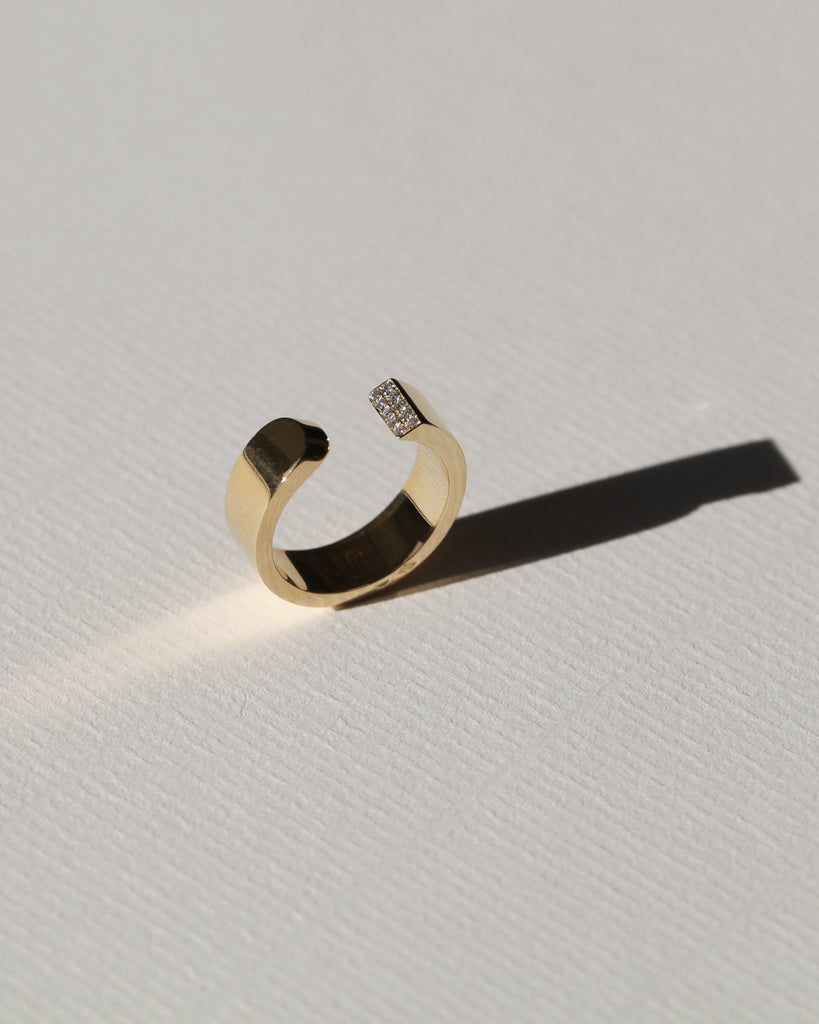 LA BEAUTÉ nous inspire le calme, une force intérieure et maîtrisée. Le parfait équilibre.   La sophistication dans la simplicité. Bague aux inspirations architecturales, ses formes pleines et denses se découpent de manière incisive. Deux rangs de diamants illuminent le biais et soulignent le contraste entre la droite et la courbe.