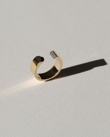 LA BEAUTÉ nous inspire le calme, une force intérieure et maîtrisée. Le parfait équilibre.   La sophistication dans la simplicité. Bague aux inspirations architecturales, ses formes pleines et denses se découpent de manière incisive. Deux rangs de diamants illuminent le biais et soulignent le contraste entre la droite et la courbe.