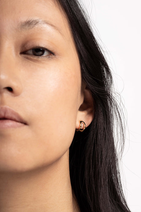 Boucles d'oreilles Maison Mouche au design épuré et architectural, en vermeil 100% recyclé et tracé, fabriquées dans des ateliers eco-responsables en Italie. Cette mini boucle L'AVENTURE enrobe discrètement l'oreille, elle est un jeu d’oppositions et de ruptures entre courbes et segments. Les biais accentuent les perspectives, la lumière avive les angles et découpe les espaces.
