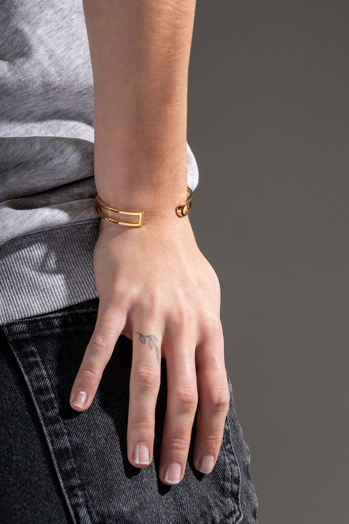 La famille L'AVENTURE se complète de son élégant bracelet manchette. L'AVENTURE est un jeu d’oppositions et de ruptures entre courbes et segments. Les biais accentuent les perspectives, la lumière avive les angles et découpe les espaces. Graphique et épuré, ce bracelet ouvert s'adapte parfaitement à votre poignet, il est léger, ultra-confortable, ne tourne pas et ne vous gênera pas dans vos mouvements.