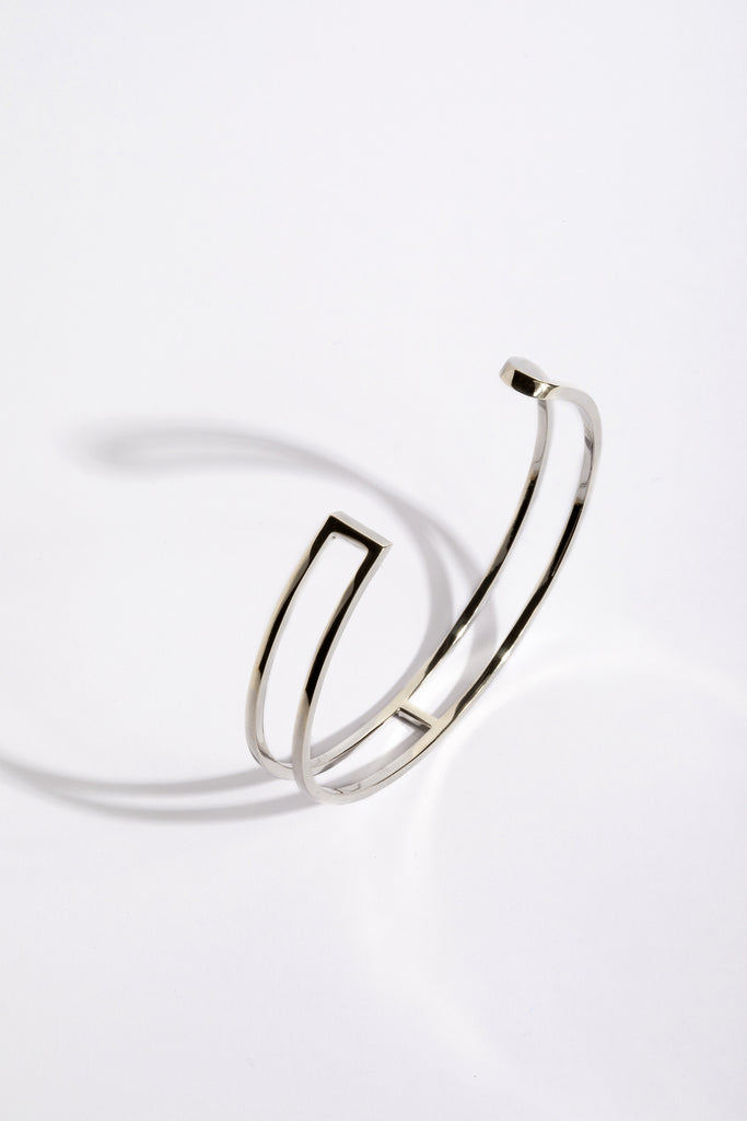 La famille L'AVENTURE se complète de son élégant bracelet jonc. L'AVENTURE est un jeu d’oppositions et de ruptures entre courbes et segments. Les biais accentuent les perspectives, la lumière avive les angles et découpe les espaces. Graphique et épuré, ce bracelet ouvert s'adapte parfaitement à votre poignet, il est léger, ultra-confortable, ne tourne pas et ne vous gênera pas dans vos mouvements.