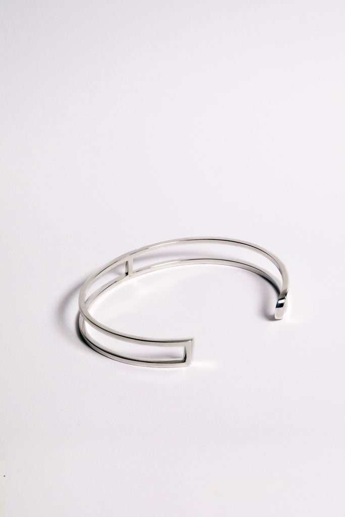 La famille L'AVENTURE se complète de son élégant bracelet jonc. L'AVENTURE est un jeu d’oppositions et de ruptures entre courbes et segments. Les biais accentuent les perspectives, la lumière avive les angles et découpe les espaces. Graphique et épuré, ce bracelet ouvert s'adapte parfaitement à votre poignet, il est léger, ultra-confortable, ne tourne pas et ne vous gênera pas dans vos mouvements.